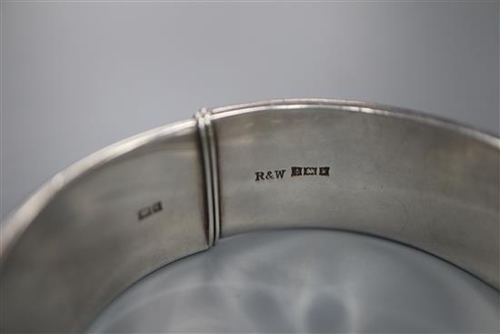 A 1970s textured silver hinged bracelet, with checkered decoration, by Rigby & Wilson, gross 46 grams.